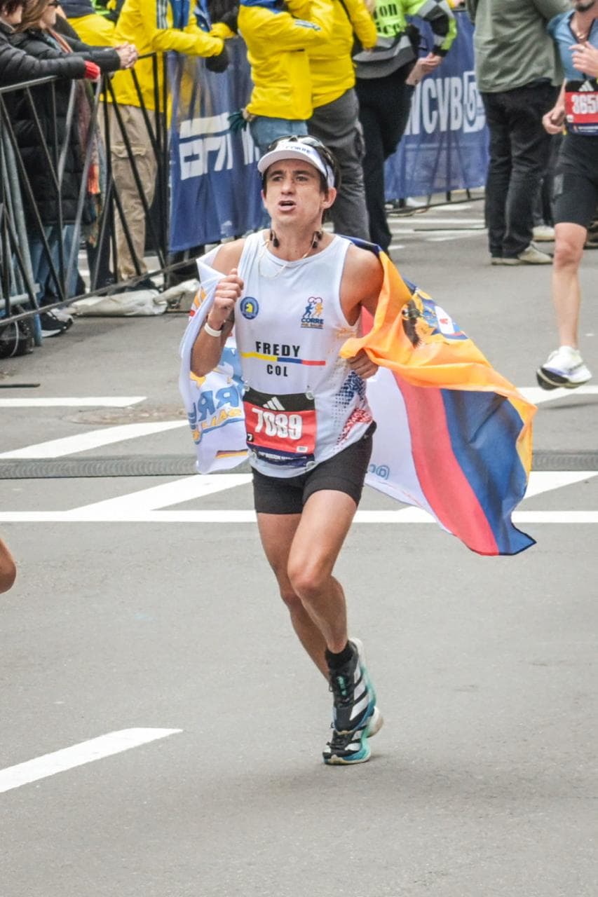 Dr. Fredy Báez corriendo Boston Marathon con la bandera de Colombia